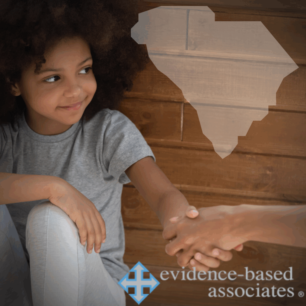 Young girl sitting against a wooden wall shakes hands with an adult; a South Carolina state outline and Evidence-Based Associates logo are visible.