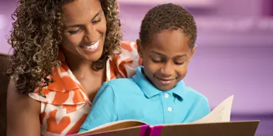 In-Kind-Card-Image African-American woman reading a book to her toddler son.