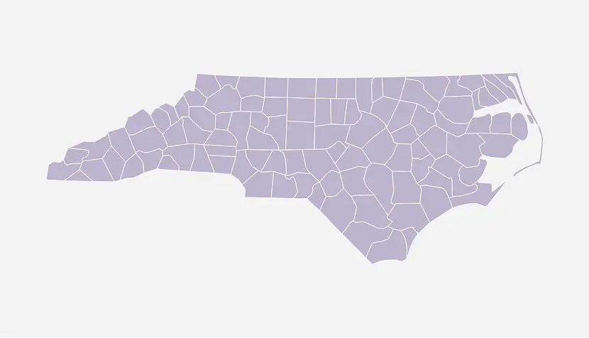 Outline map of North Carolina showing the state’s county boundaries in light purple on a light gray background.