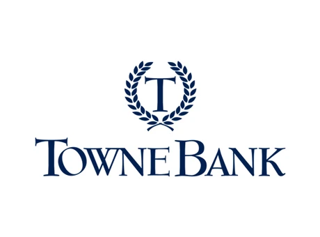 TowneBank logo with a stylized letter "T" inside a laurel wreath above the words "TowneBank" in bold, blue, capital letters, symbolizing trust and partnership—values shared with Becoming a Partner at Thompson Child and Family Focus.