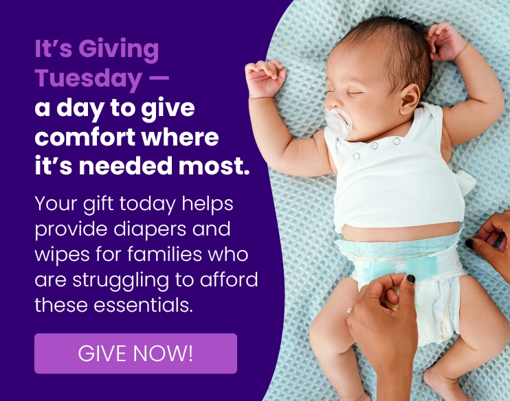 Adult hands put a diaper on a sleeping baby with a pacifier; text promotes donating diapers and wipes for families in need on Giving Tuesday.